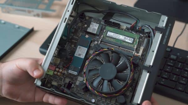 a person holding a laptop with a fan in their hand