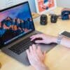 MacBook Pro turned on beside white ceramic mug