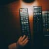three black remote controls on wooden table