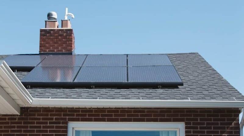 brown brick house with solar panels on roof