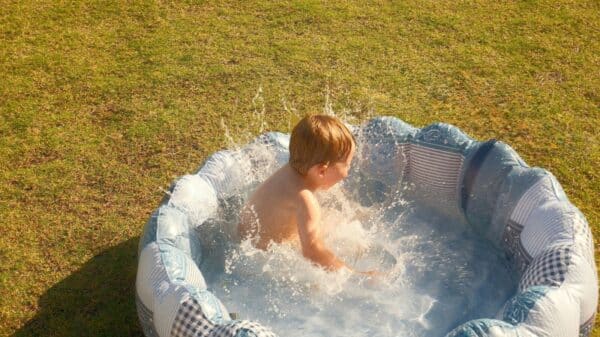 A child splashes in a small inflatable pool.