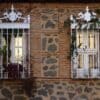 Two ornate windows with decorative iron bars.