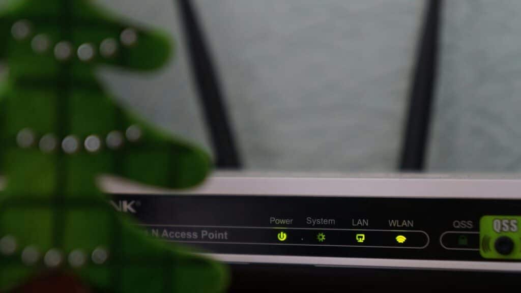 white and black modem router with four lights
