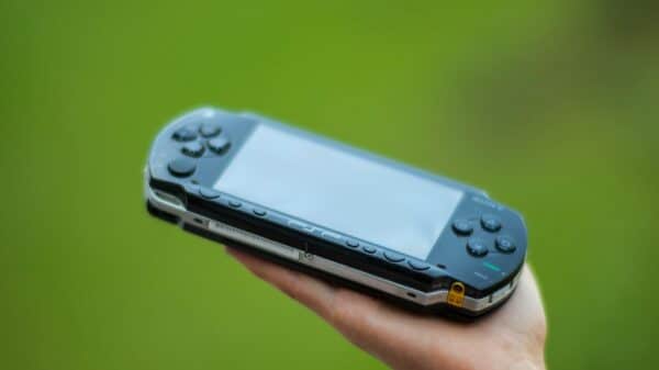 person holding blue sony ps 4 game console