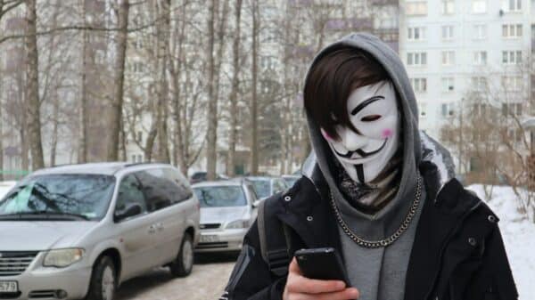 a person wearing a mask and holding a cell phone