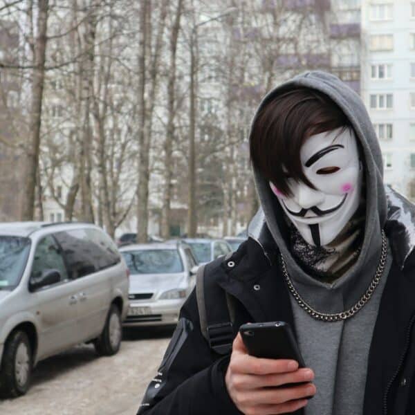 a person wearing a mask and holding a cell phone