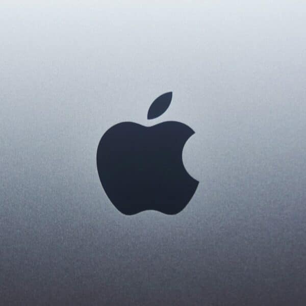 A dark apple logo centered on a smooth grey metallic surface