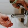 person holding stainless steel faucet