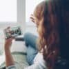 Woman watching video on smartphone by window