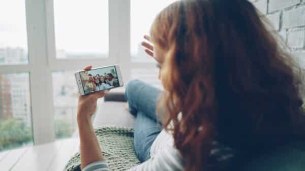 Woman watching video on smartphone by window