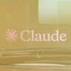 Pink claude logo on a golden background with clear elements